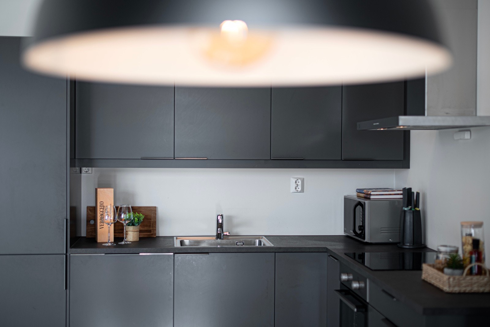 Kjøkkenet har benkeplate av komposittlaminat og fremstår som stilrent og delikat. Belysning under overskap. Galleribilde