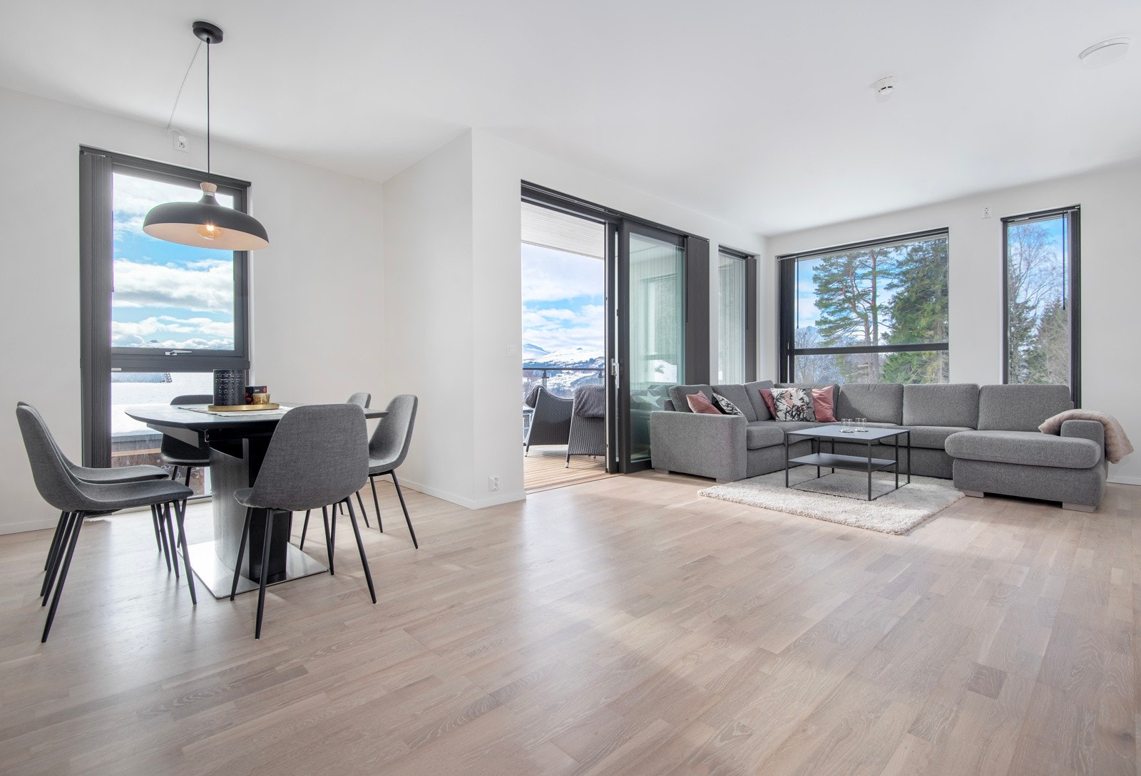 Lyst parkettgulv med termostatstyrt varme. Vinduer har lameller for skjerming. Galleribilde