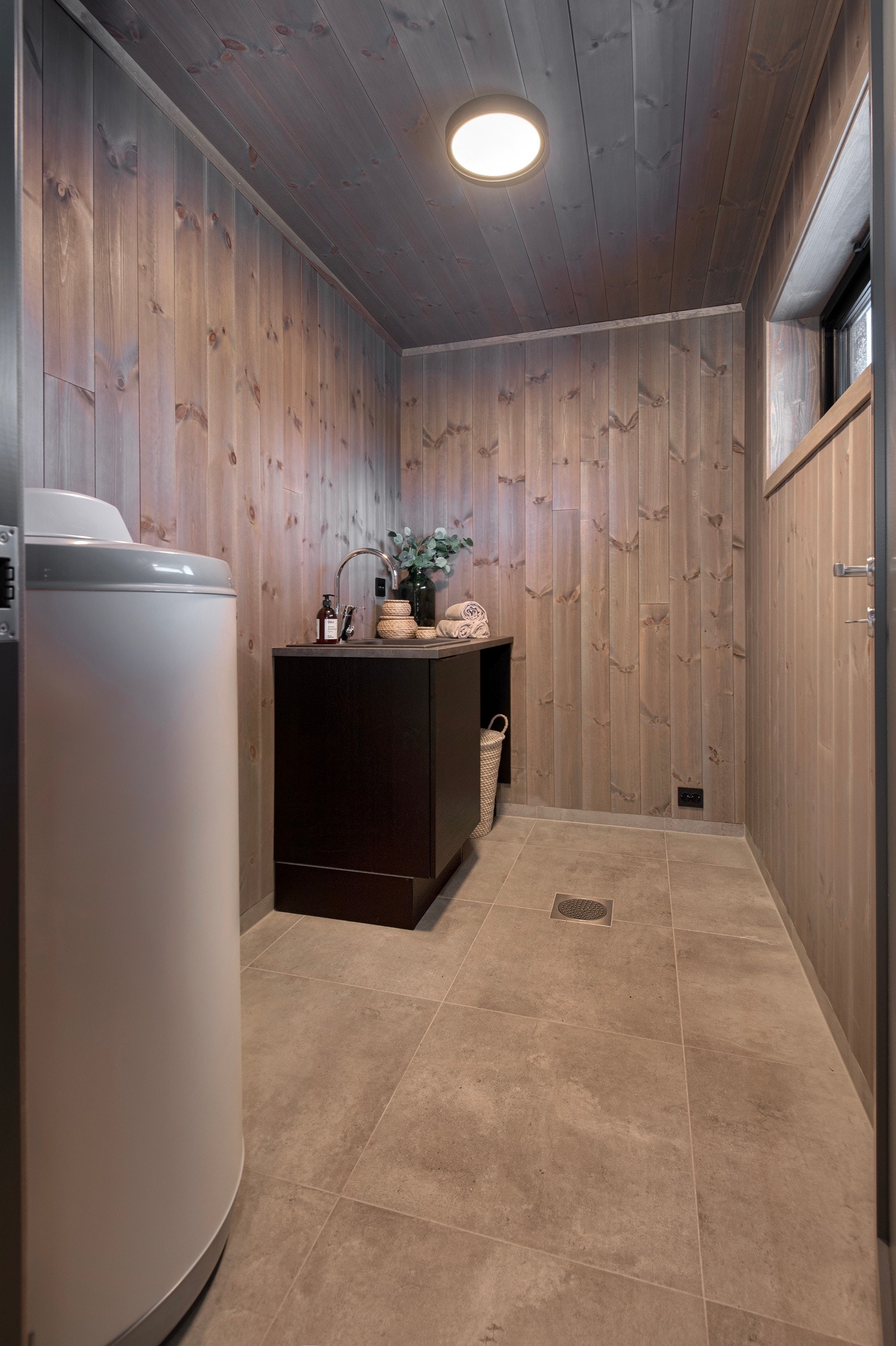 Vaskerom med fliser på gulvet. Her er innredning fra HTH. Opplegg for vaskemaskin. Galleribilde