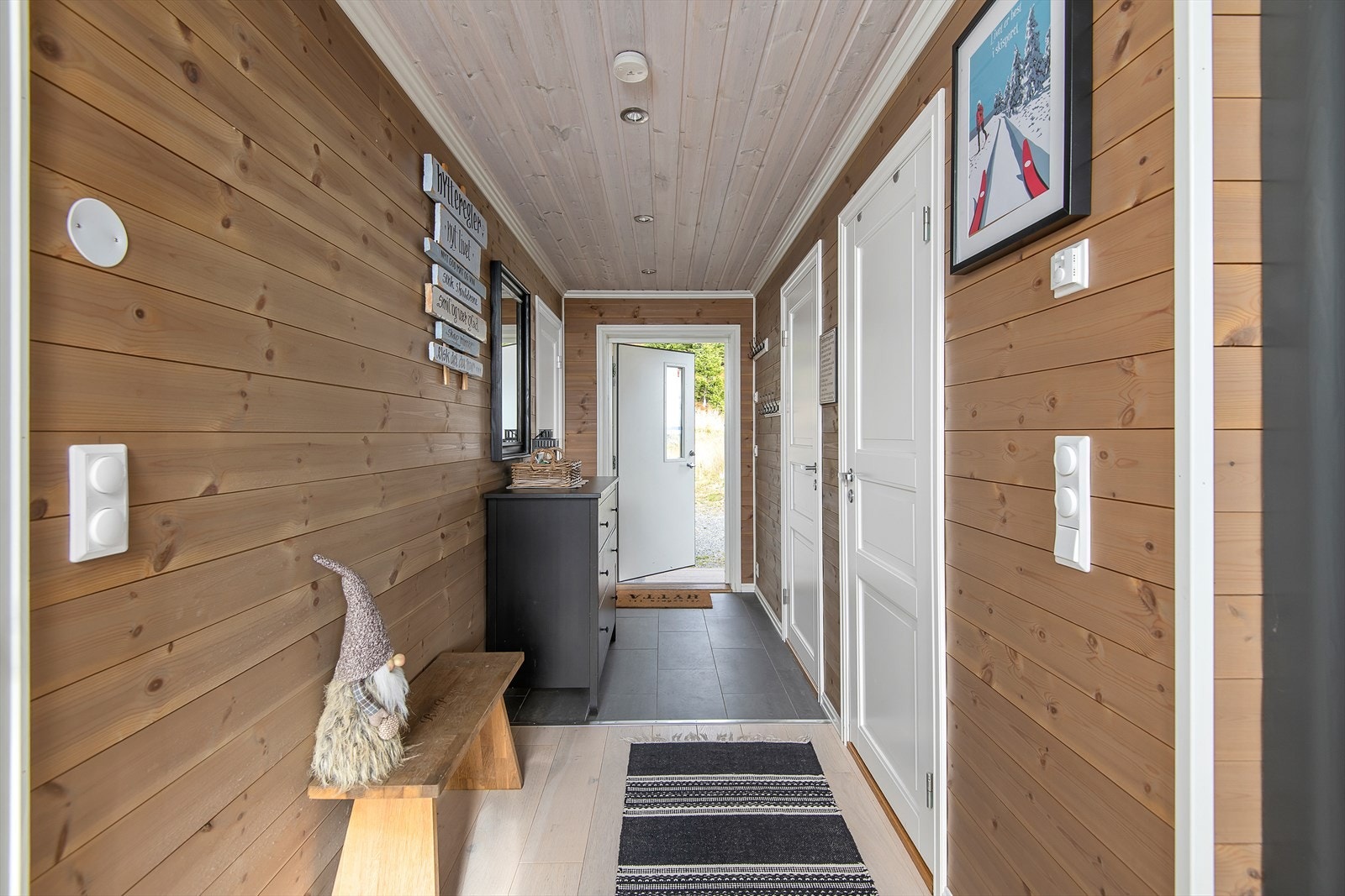 Romsig gang, med flislagt gulv i den ytre delen. Plass til å henge fra seg yttertøy og utstyr. Fra gangen er det adkomst til soverommene og til badet. Galleribilde