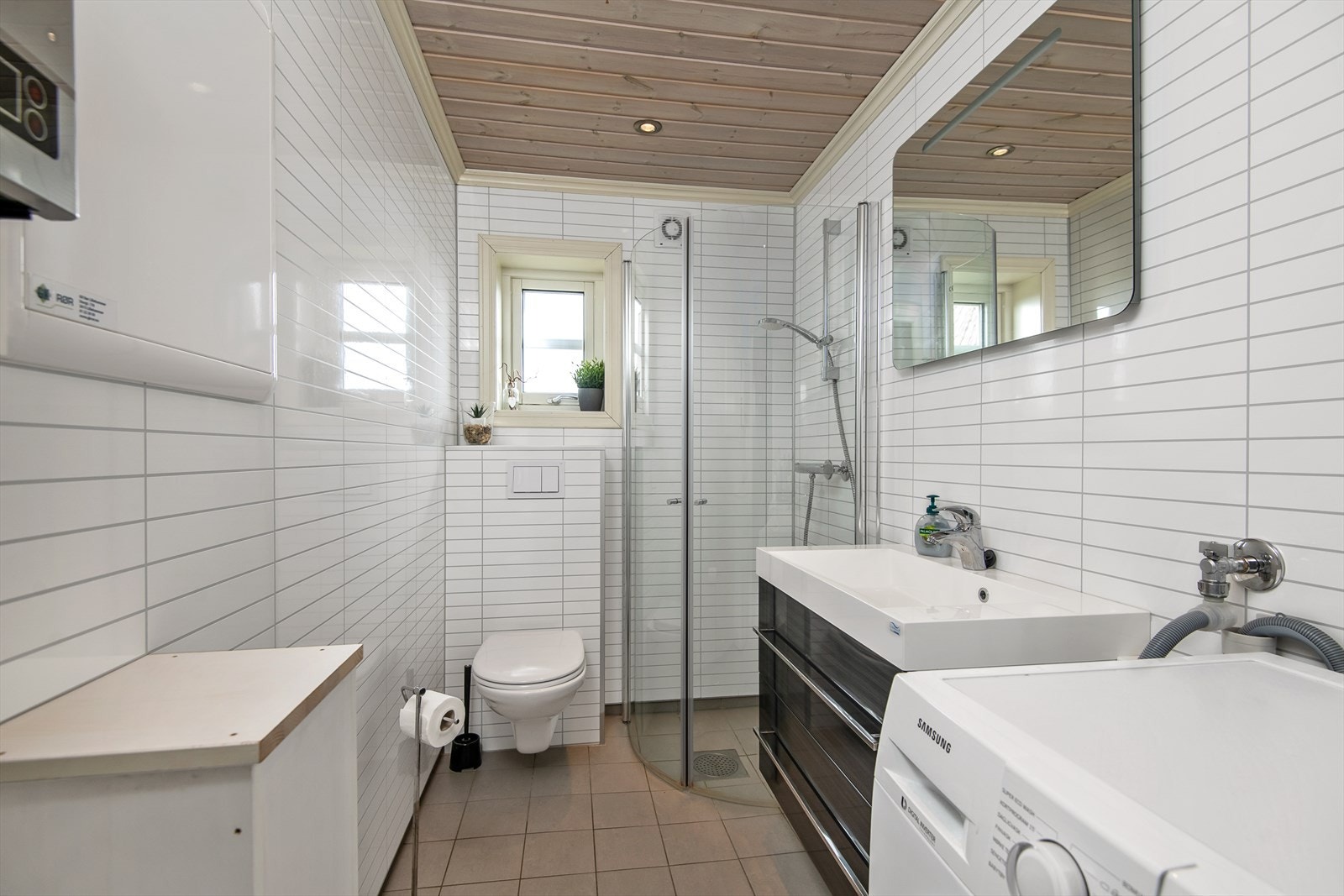 Stilrent bad/wc med servantinnredning, dushjørne og vegghengt WC. Galleribilde