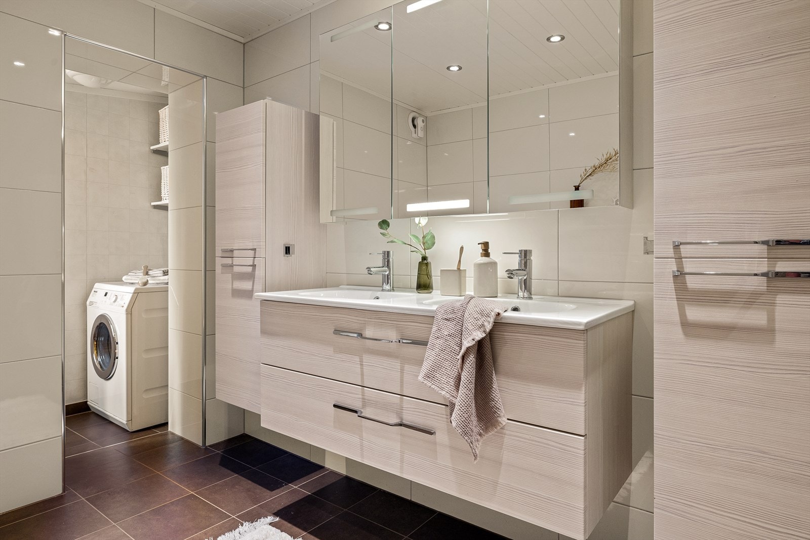 Deler av badet er innredet som vaskerom med opplegg for vaskemaskin. Galleribilde