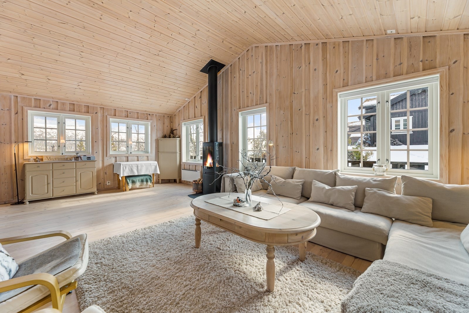 Hytta har en lys og innbydende stue med store vindusflater. Galleribilde