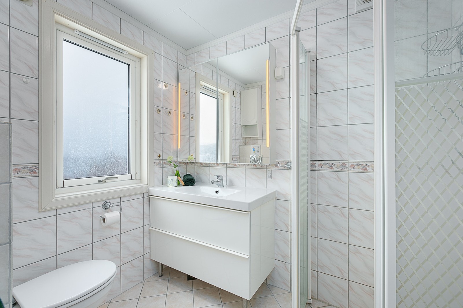 Bad i første etasje med dusjsone og vegghengt toalett. Galleribilde