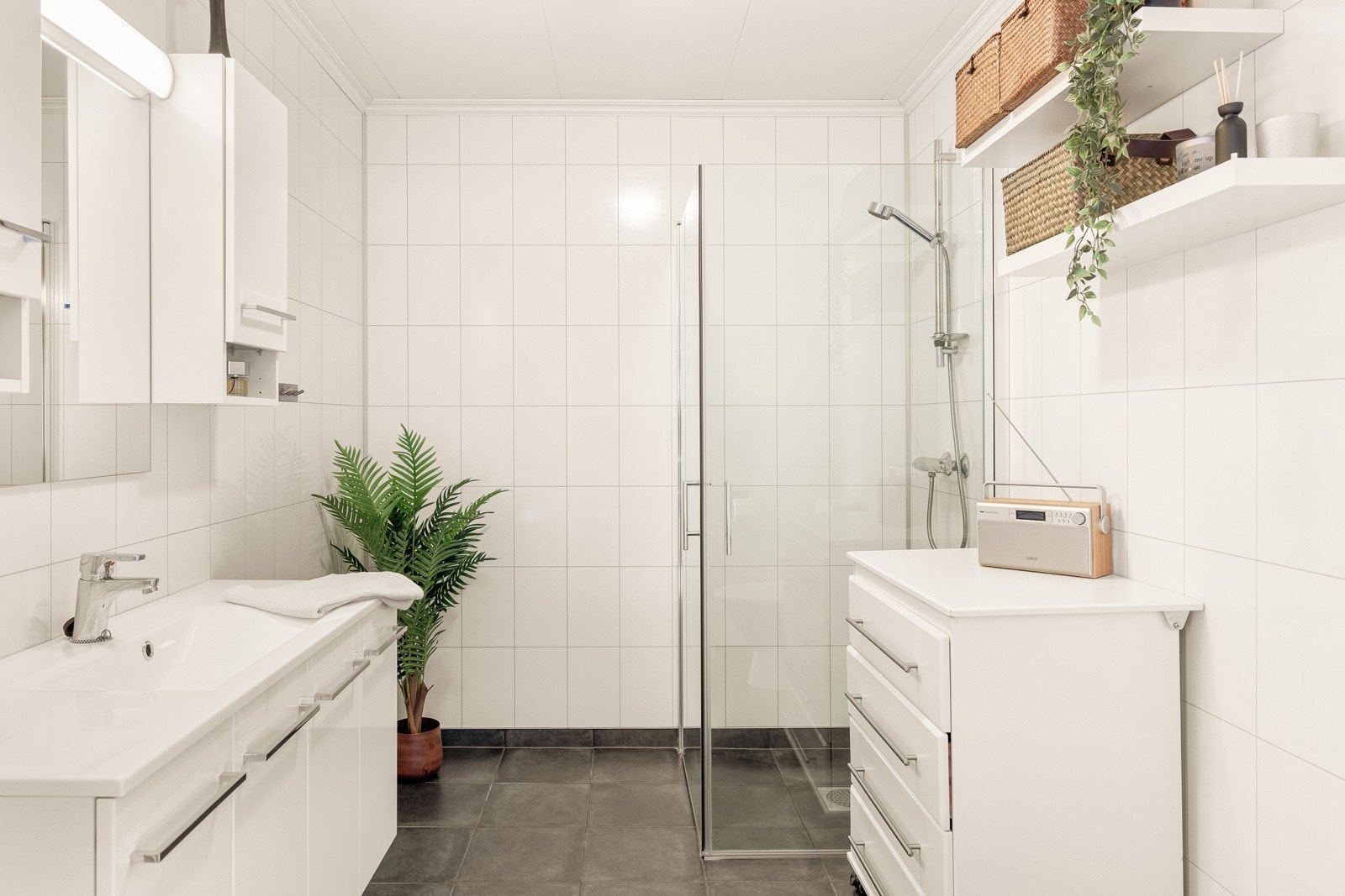 Lyst og stilrent bad med baderomsplater på vegg. Fliset gulv med varmekabler. Galleribilde