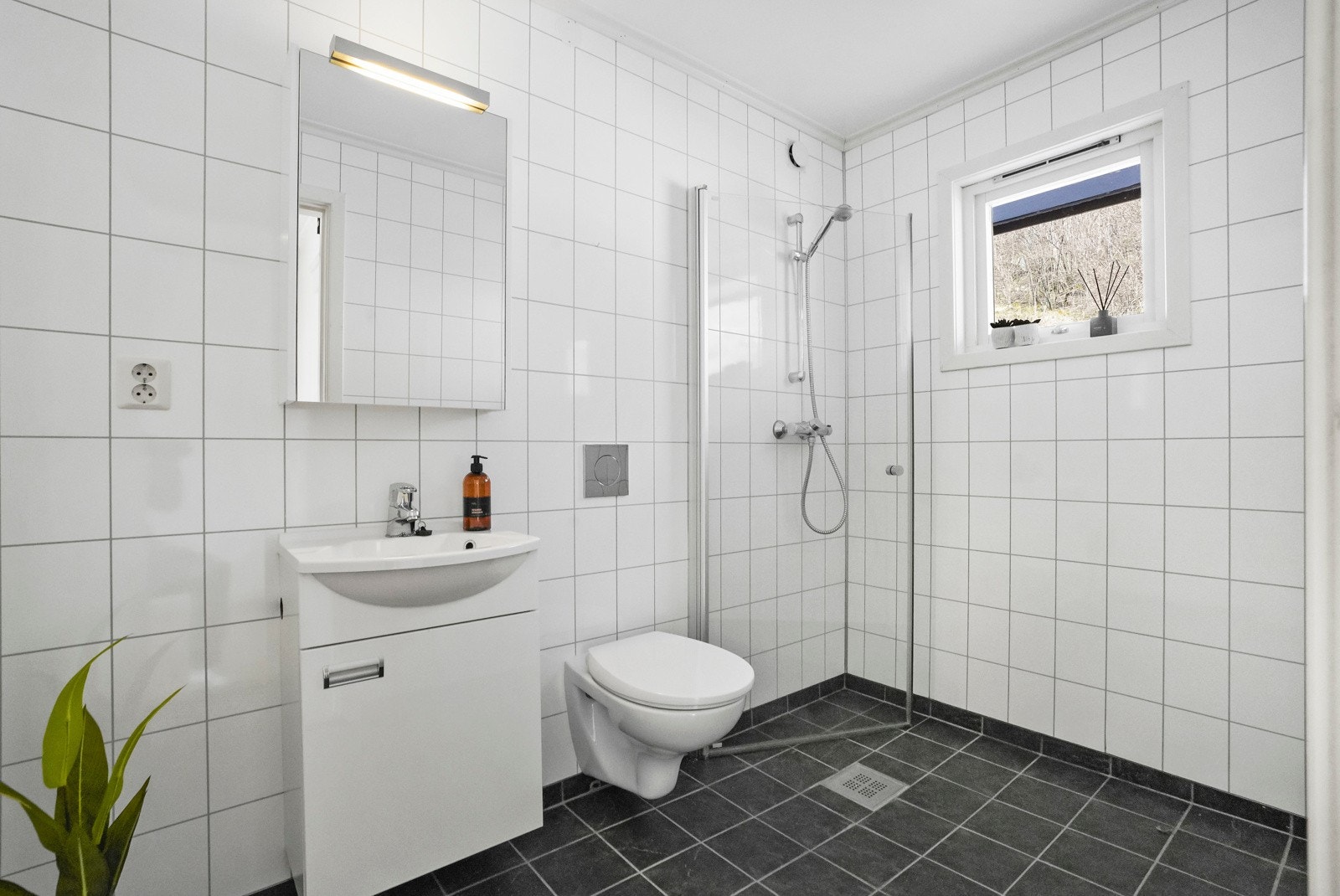 Badet har tidløse overflater, vegghengt klosett og nyere innredning - det er også opplegg for vaskemaskin Galleribilde