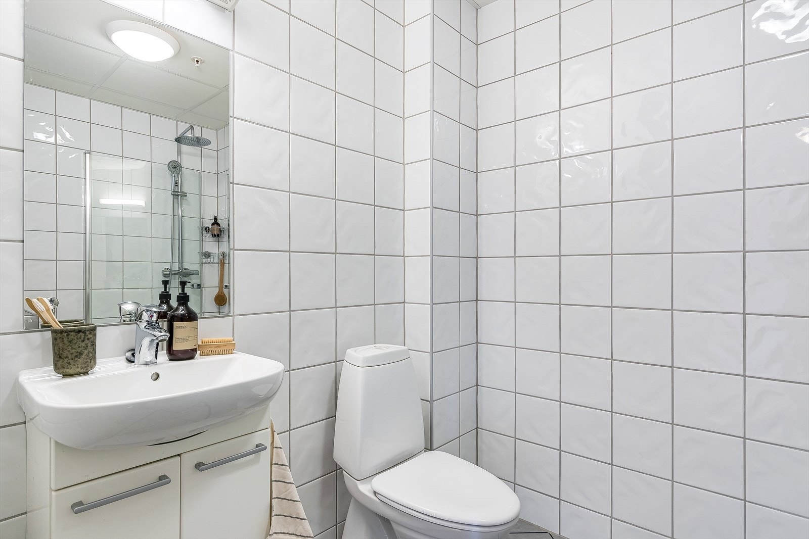 Pent, flislagt bad med varmekabler i gulv og opplegg for vaskemaskin. Galleribilde