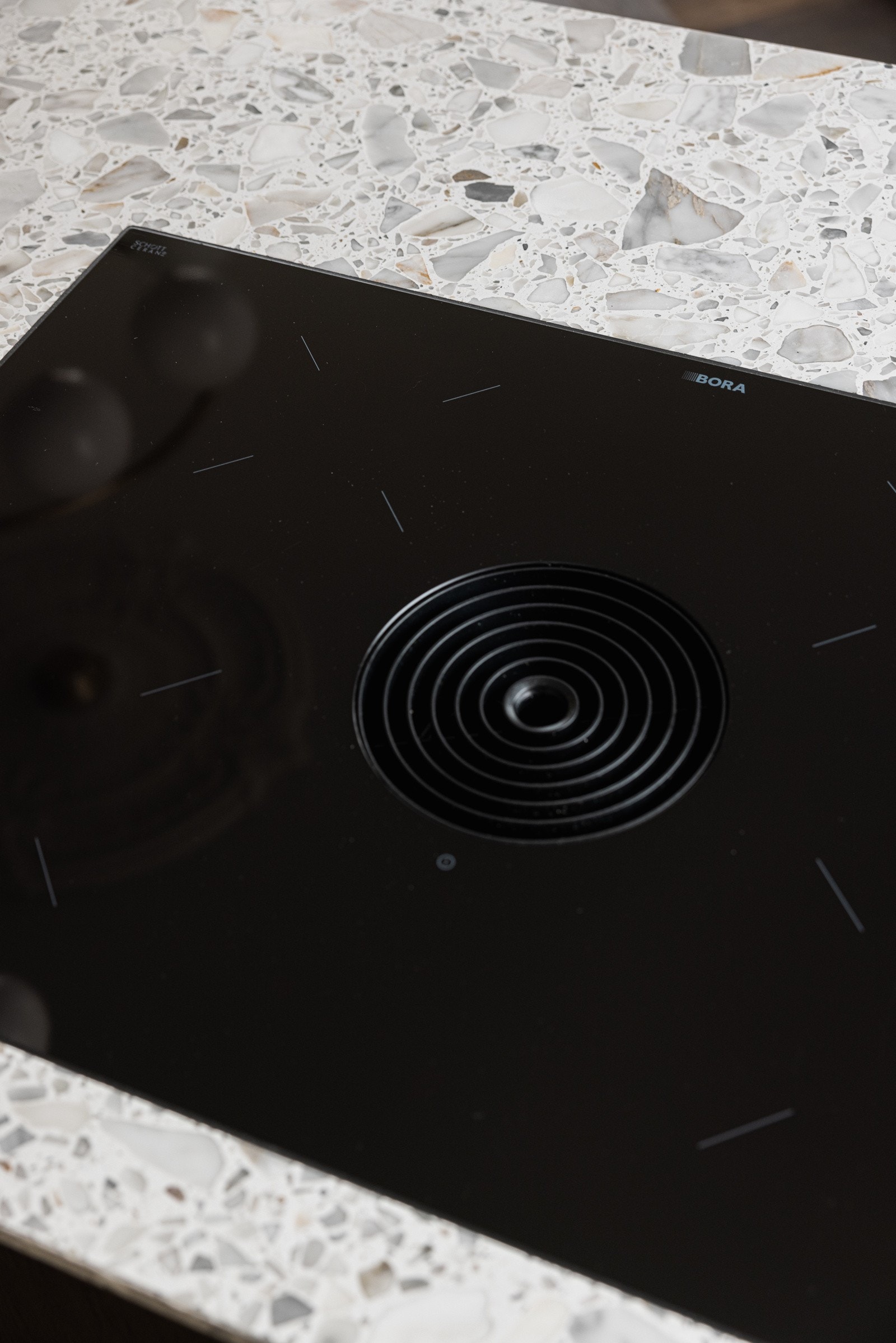 Bora platetopp med integrert ventilator. Det er montert stikkontakter i kjøkkenøyen. Galleribilde