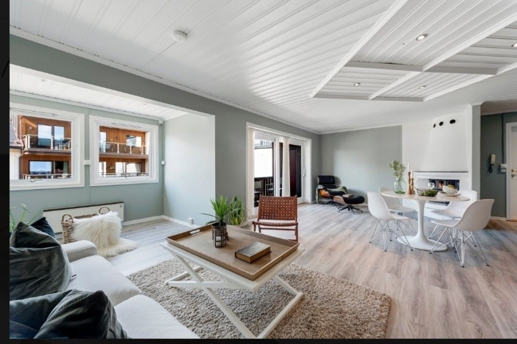 Bilde fra sofa og kjøkken mot peis og veranda. Galleribilde