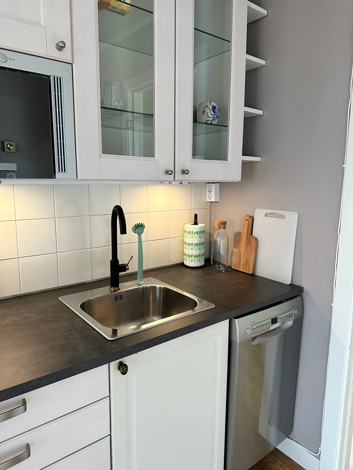 Kjøkken med oppvaskmaskin, innebygd mikrobølgeovn og komfyr. Galleribilde
