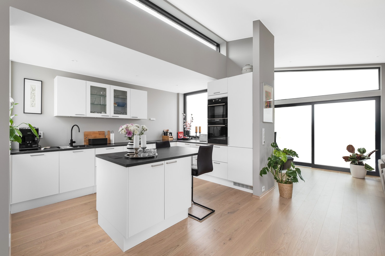 Midt i rommet ligger kjøkkenet i en utstikker som gir en naturlig skjerming. Foto fra bolig i andre byggetrinn. Galleribilde