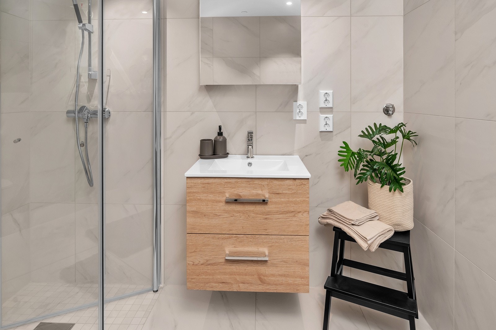 Badet inneholder servant med speil, dusjhjørne, WC og opplegg til vaskemaskin. Bilde fra tilsvarende leilighet Galleribilde
