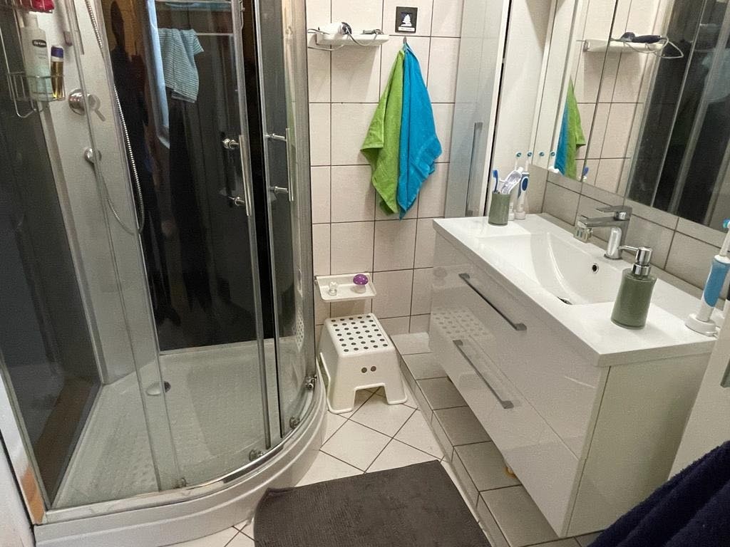 Bad 1 hel fliset og varmekabel på gulvet med både badekar og dusjkabinett Galleribilde