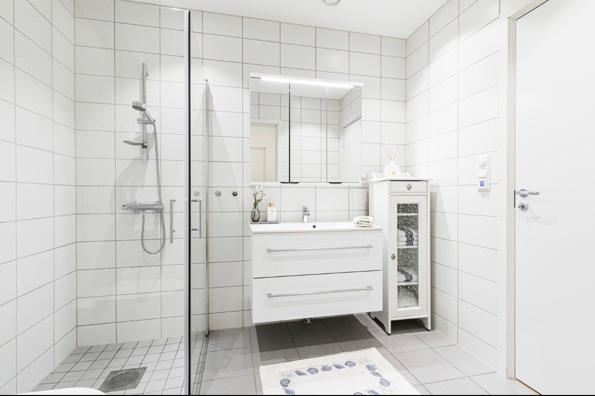 Innredningen består av servant med hvite skuffer og et stort speilskap med belysning. Galleribilde