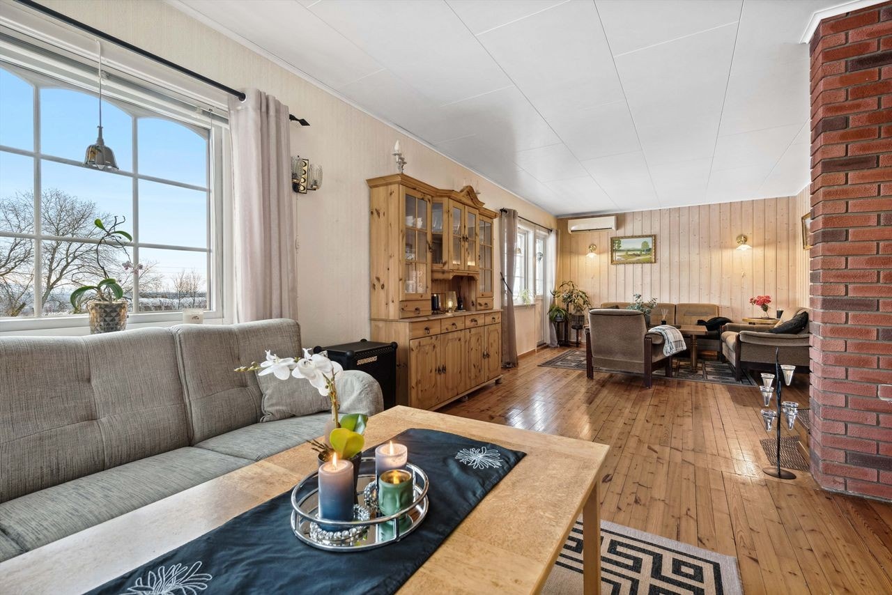 Denne strekker seg også på hver side av vedovnen og gir et naturlig skille for to sofagrupper om man ønsker. Galleribilde