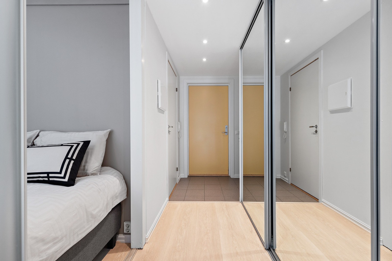 En arealeffektiv leilighet med flislagt entré, stor skyvedørsgarderobe med speilfronter og skyvedør til sovealkove Galleribilde