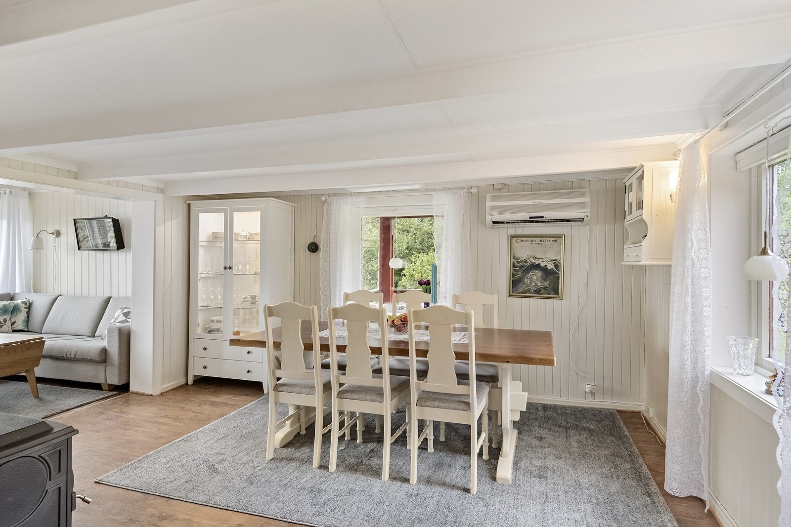 Fra kjøkkenet er det inngang til stuen. Denne delen av stuen er også en del av den opprinnelige boligen. Her er det montert vedovn og varmepumpe. Galleribilde