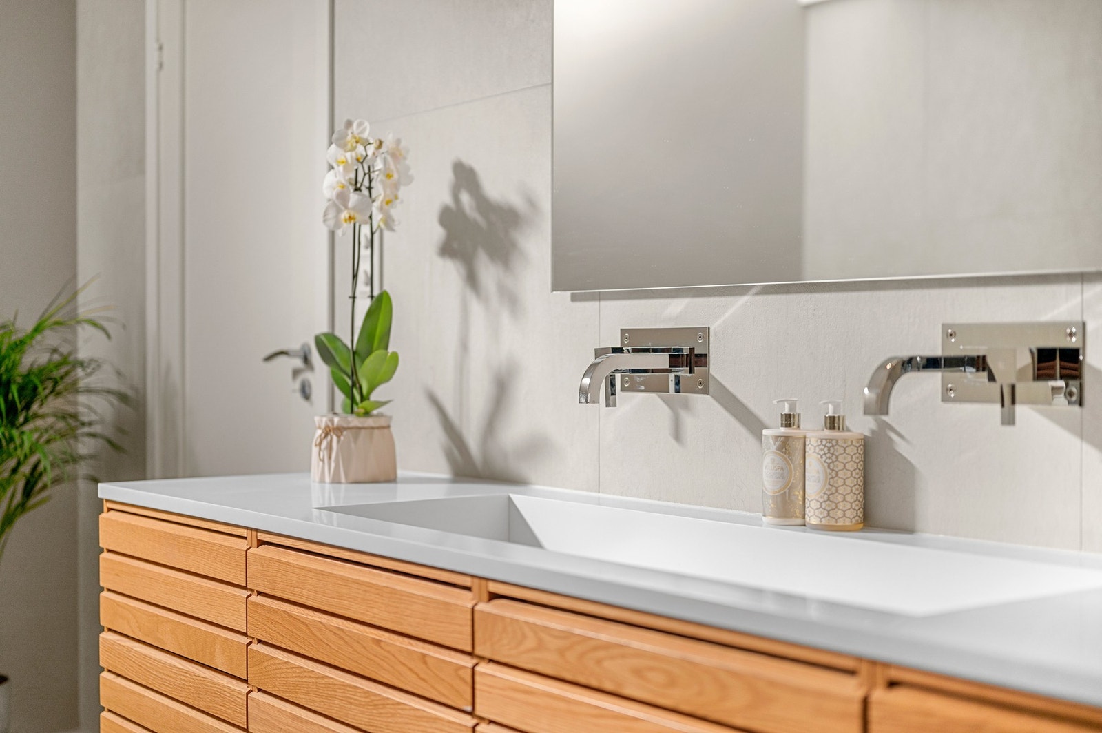 Badet er innredet med spesialdesignet baderomsinnredning fra Byåsen trevare, stor dobbel servant i Corian, og rikelig med skuffeplass samt et stort speil med dimbar belysning Galleribilde