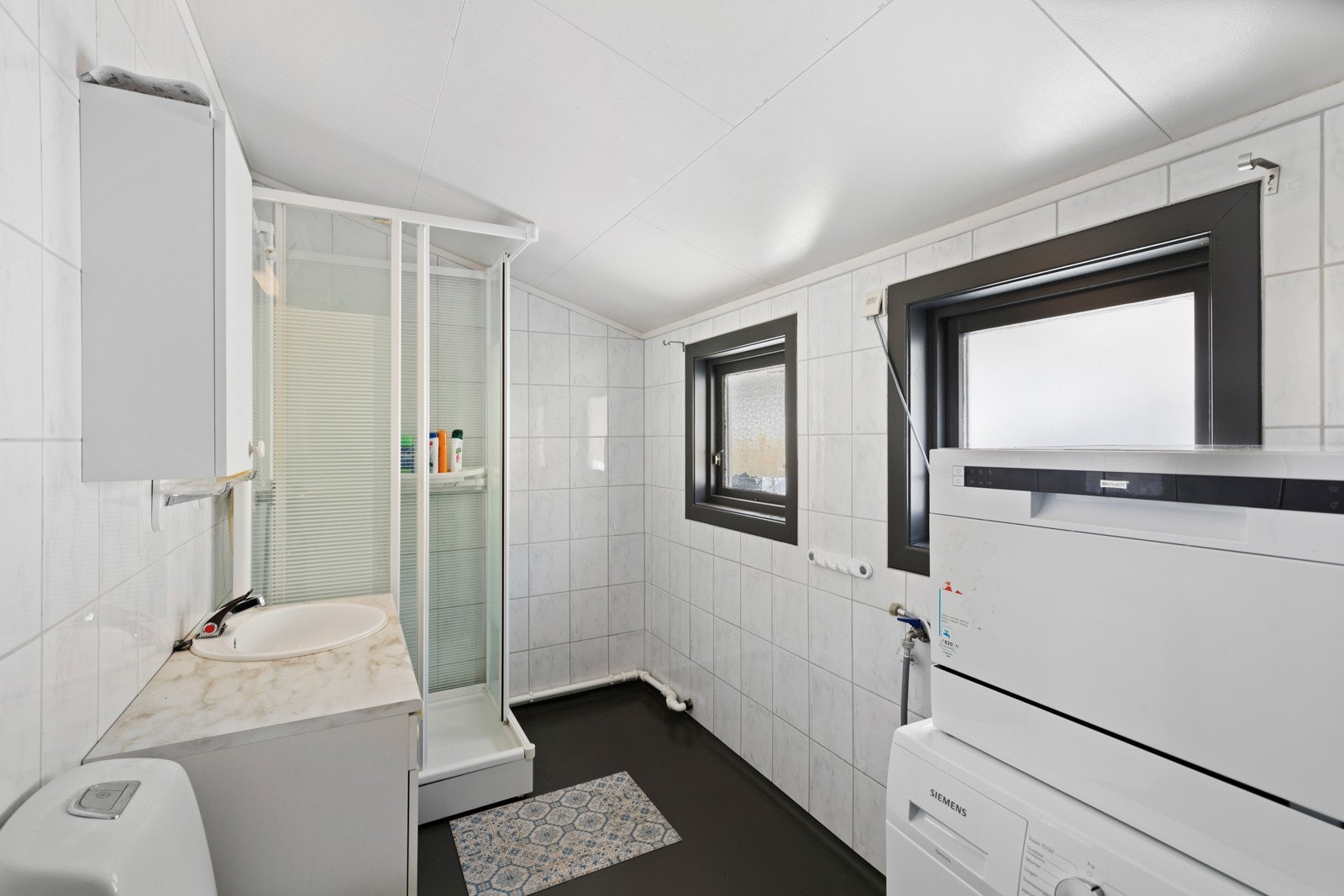 Badet har vinylbelagt gulvoverflate med gulvvarme, og fliskledde vegger. Opplegg for vaskemaskin Galleribilde