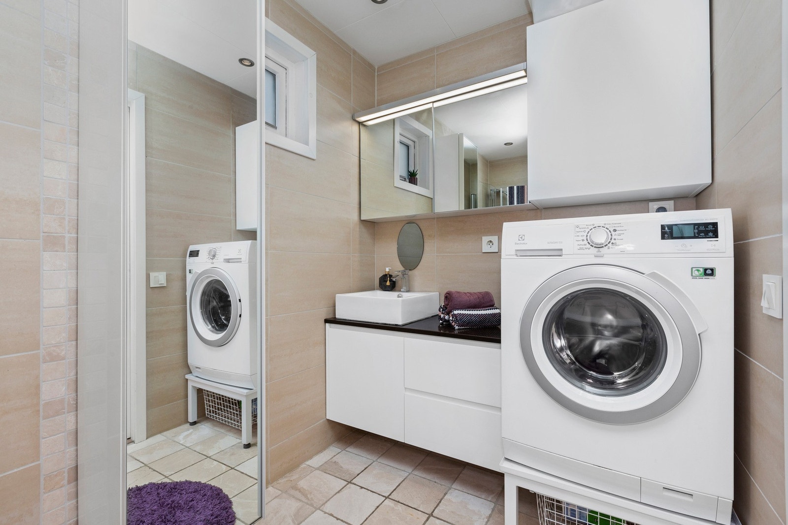 Badet er innredet med toalett, dusj med innfellbare dusjvegger, vaskemaskin, servant og skap med god oppbevaringsplass. Galleribilde