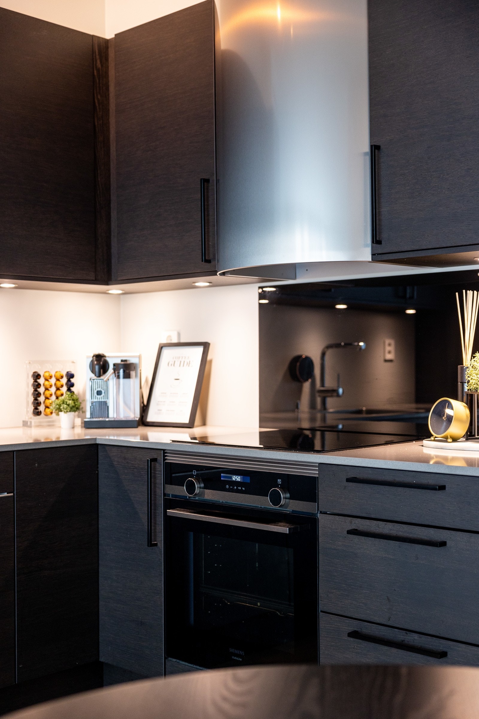 Kjøkkeninnredning med kompositt benkeplater av Silestone og slette fronter i Amfi Eik i fargen Kongle. Galleribilde