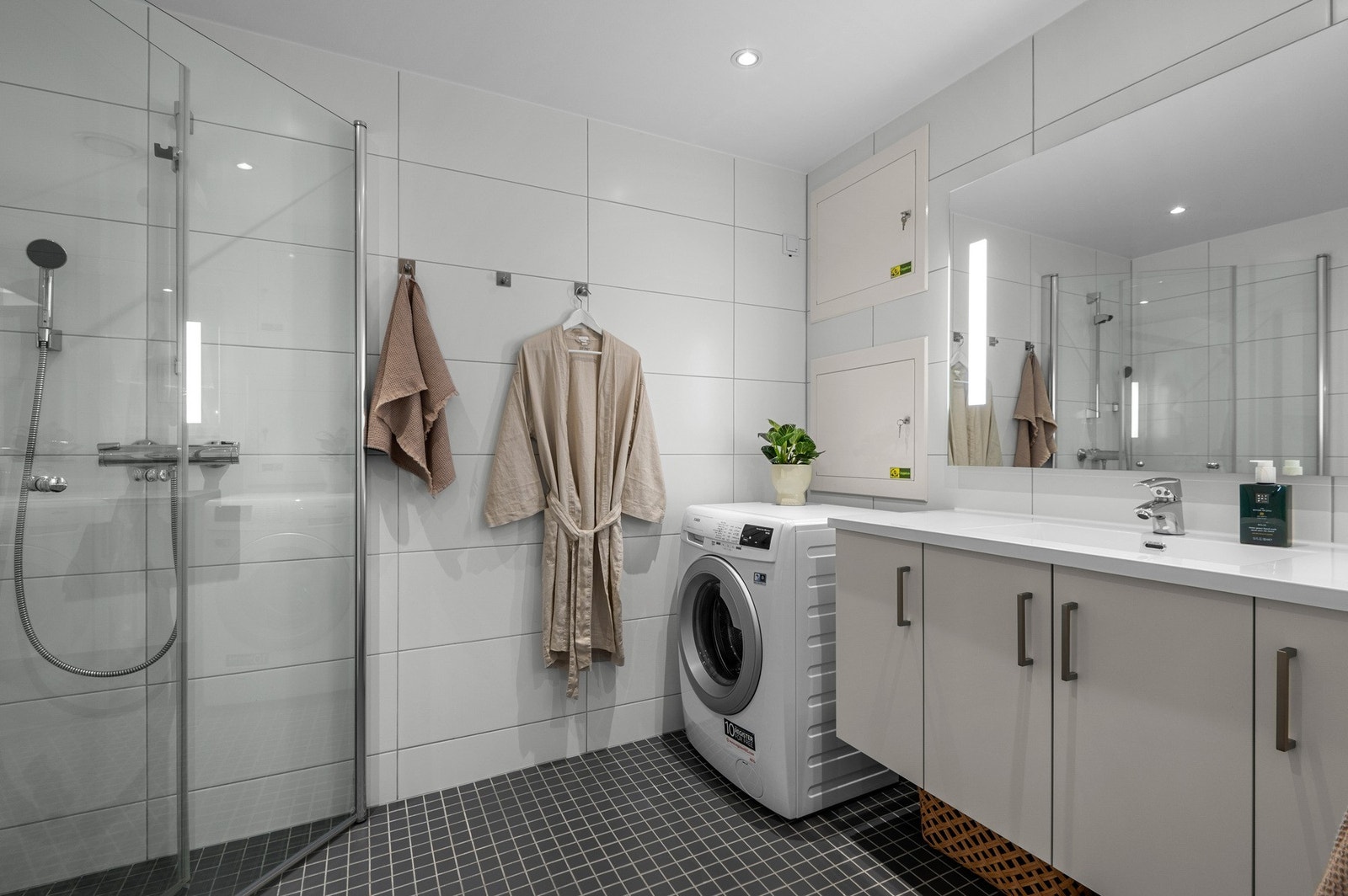 Moderne bad på 5 kvm. Badet har opplegg til vaskemaskin, samt varme i gulv og downlights i taket. Galleribilde