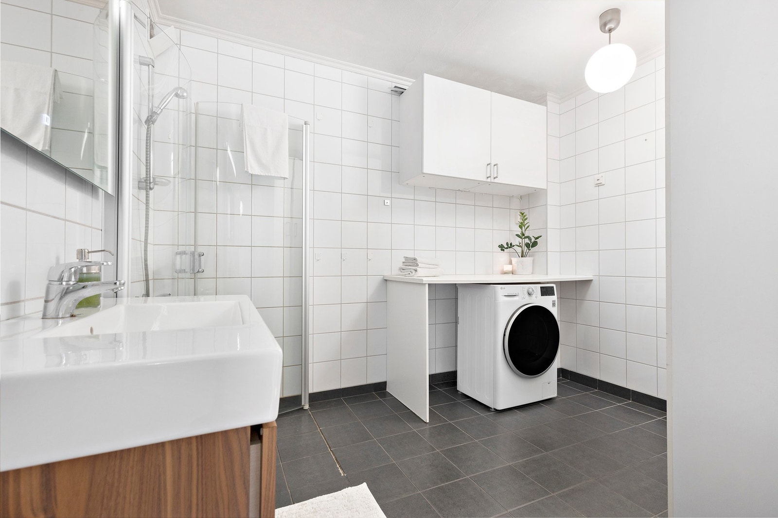 Flislagt bad med opplegg for vaskemaskin. Galleribilde