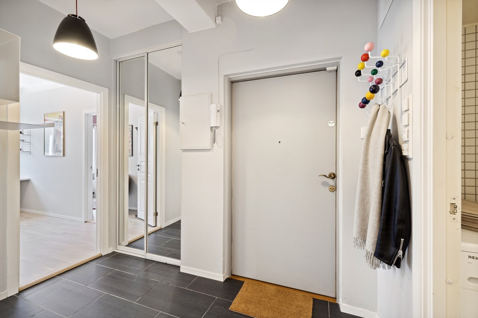 Velkommen inn! Romslig entré med plass for yttertøy og sko. Praktisk skyvedørsgarderobe med speilfronter. Galleribilde