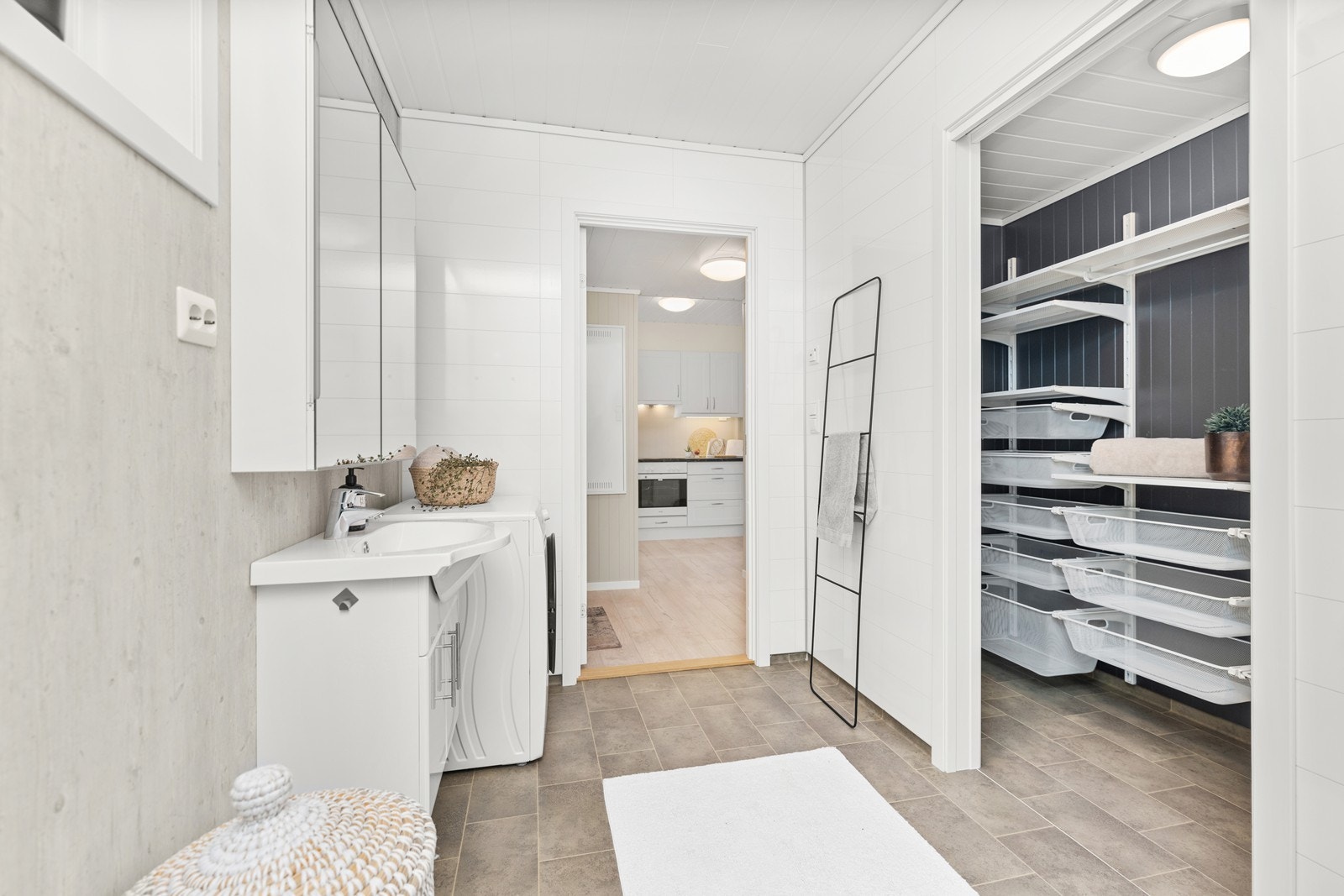 Baderom og skyvedør inn til bod/ teknisk rom med hyllesystem Galleribilde