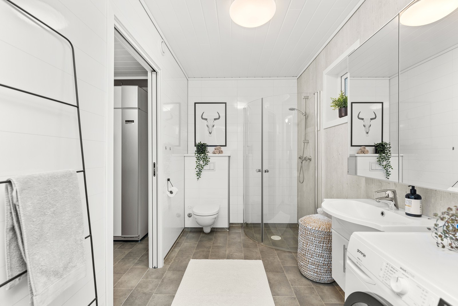 Baderom innredet med dusj på gulv, vegghengt wc og servant Galleribilde