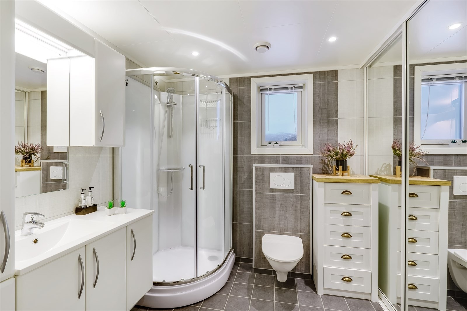 Pent bad/vaskerom med gulvvarme, våtromsplater på veggene og flis på gulvet. Galleribilde