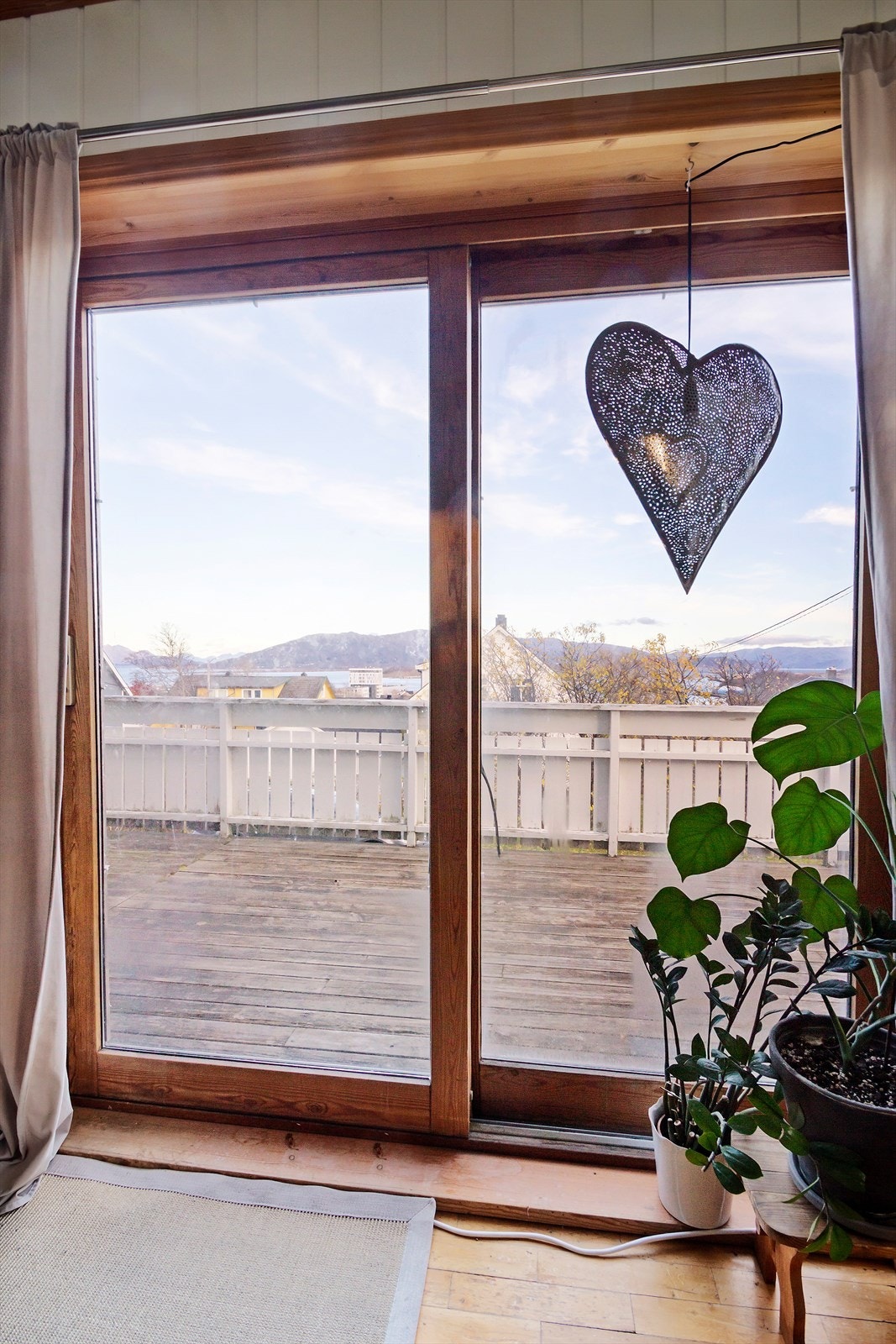 Skyvedøren i stuen gir godt med lysinnslipp og byr på en flott utsikt mot Helgelandsbrua, havet og byen. Galleribilde