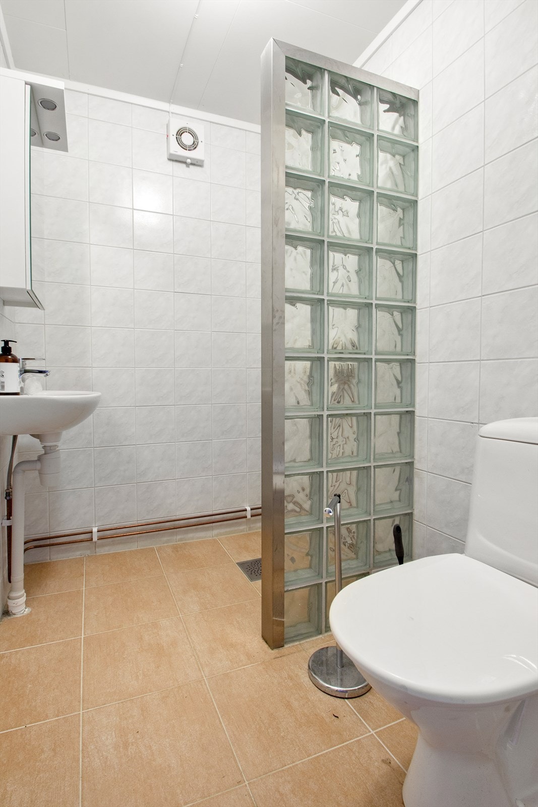 Baderommet i underetasjen har dusjnisje og servant avskilt med glassbyggersten mot wc. Galleribilde