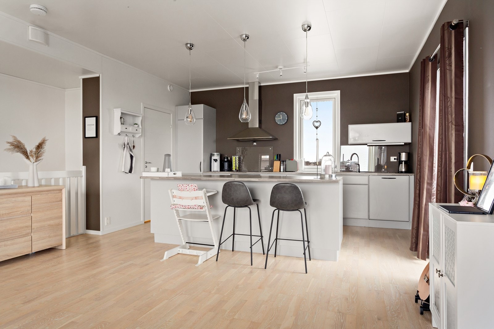 Rikelig belysning over spiseplass og skyvedøren ut mot terrassen slipper mye dagslys inn i kjøkkendelen Galleribilde