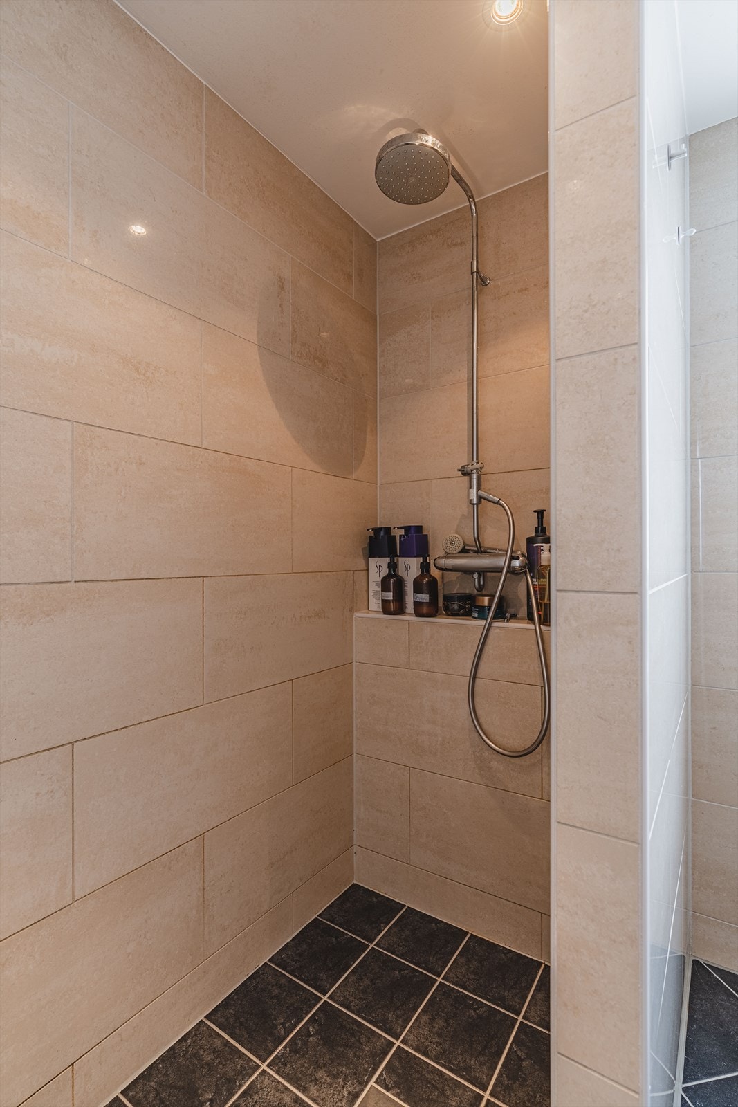 En flott dusjnisje har egen hylle for oppbevaring av shampoo og såpe. Galleribilde