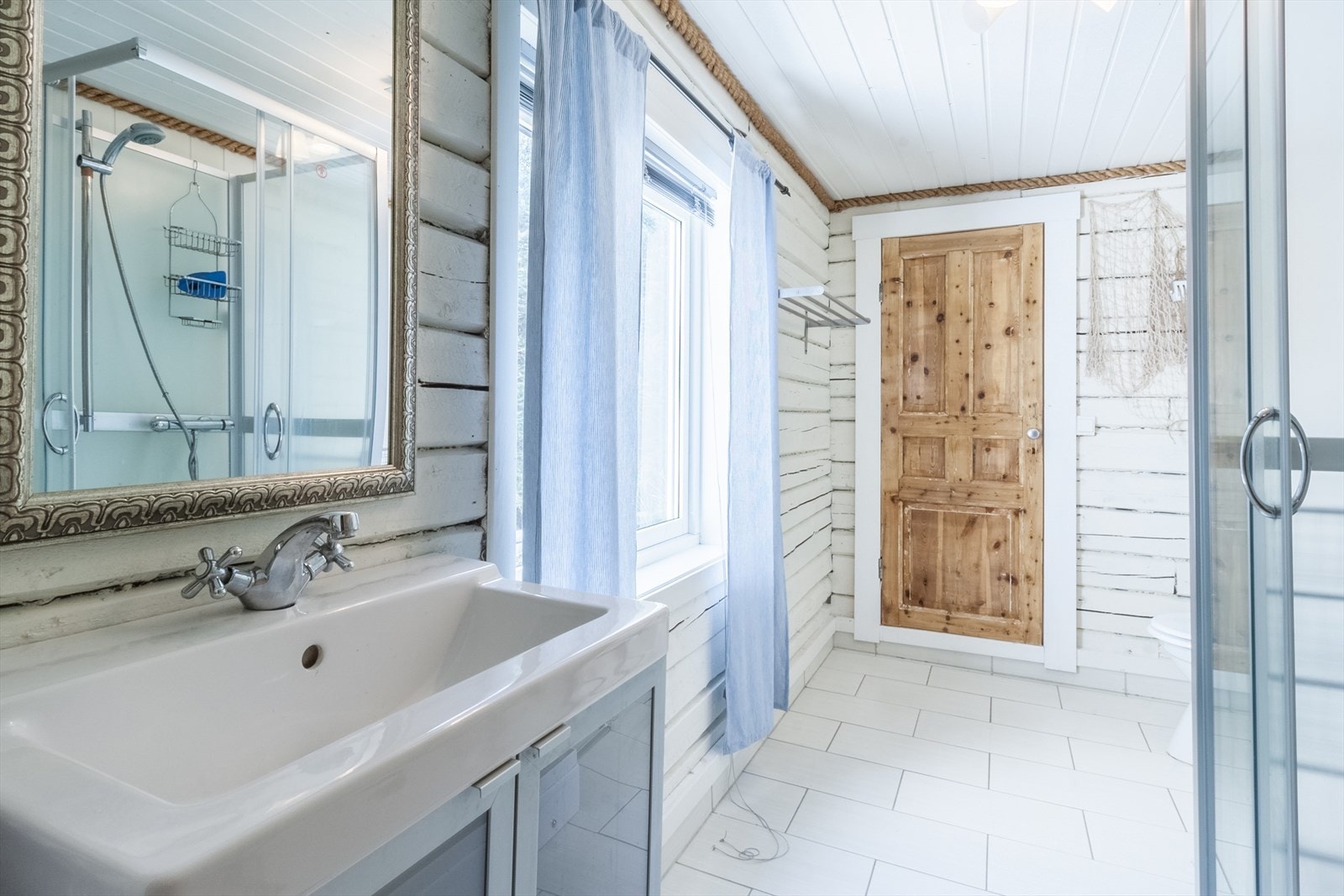Badet har fliser på gulv og malte plater på deler av veggen. Galleribilde