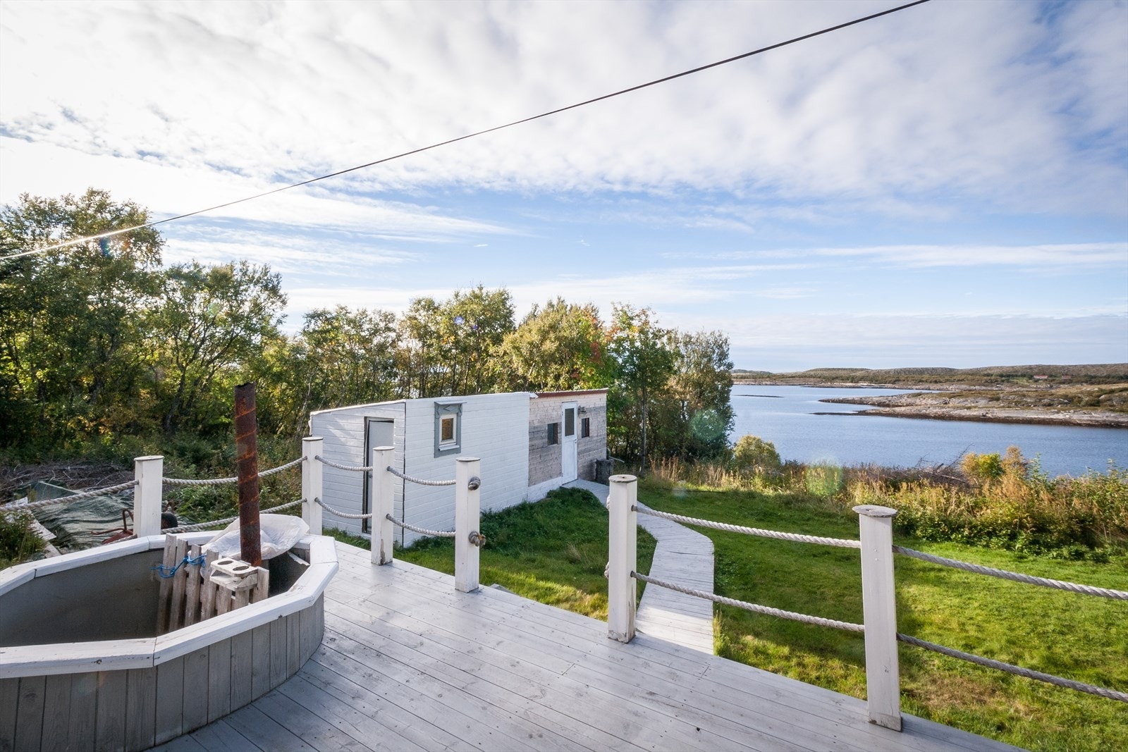 Flott utsikt fra terrasse med platting ned til uthuset. Galleribilde