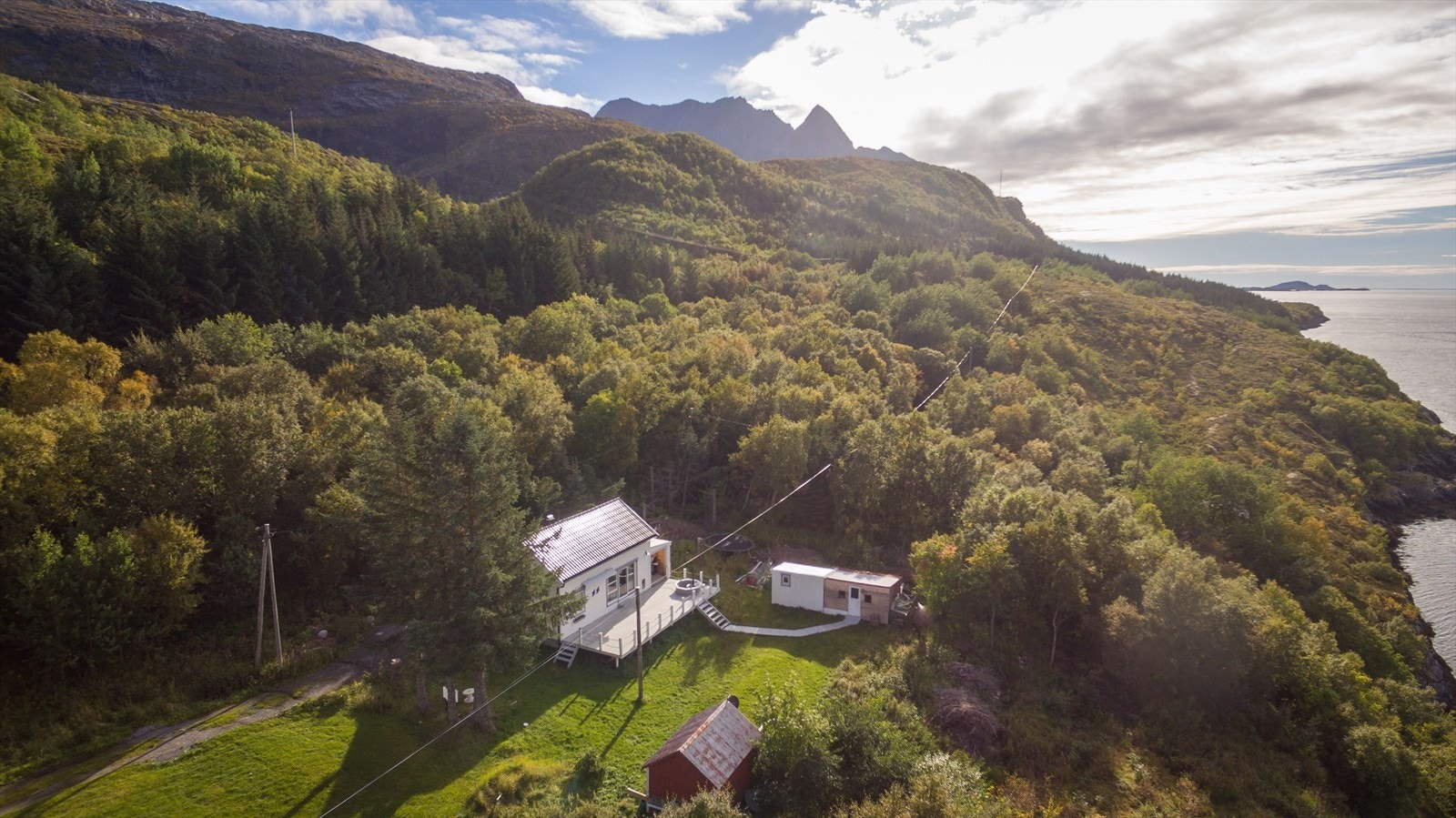 Eiendommen er godt skjermet, skogen og fjellet i bakgrunnen fungerer som naturlige hinder for sør- og østavind. Galleribilde