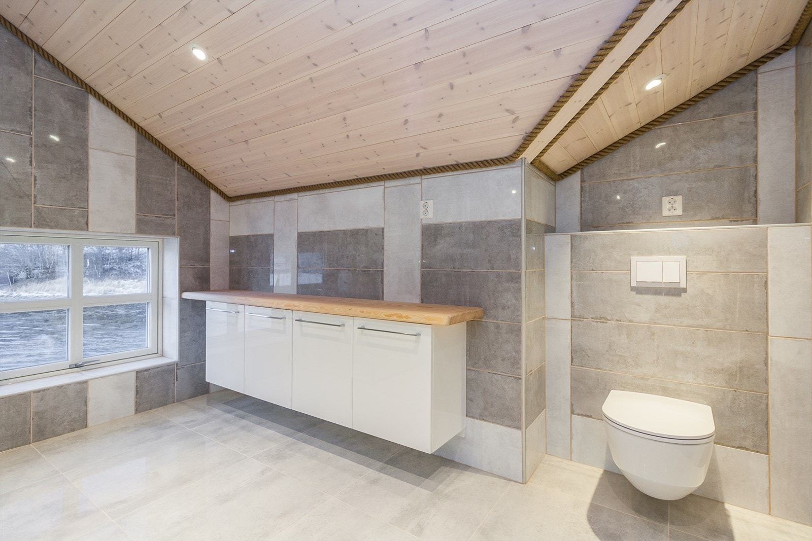 Gulv- og veggoverflater er i flislagt utførelse. Også her er det maritime uttrykket understreket med tau. Galleribilde