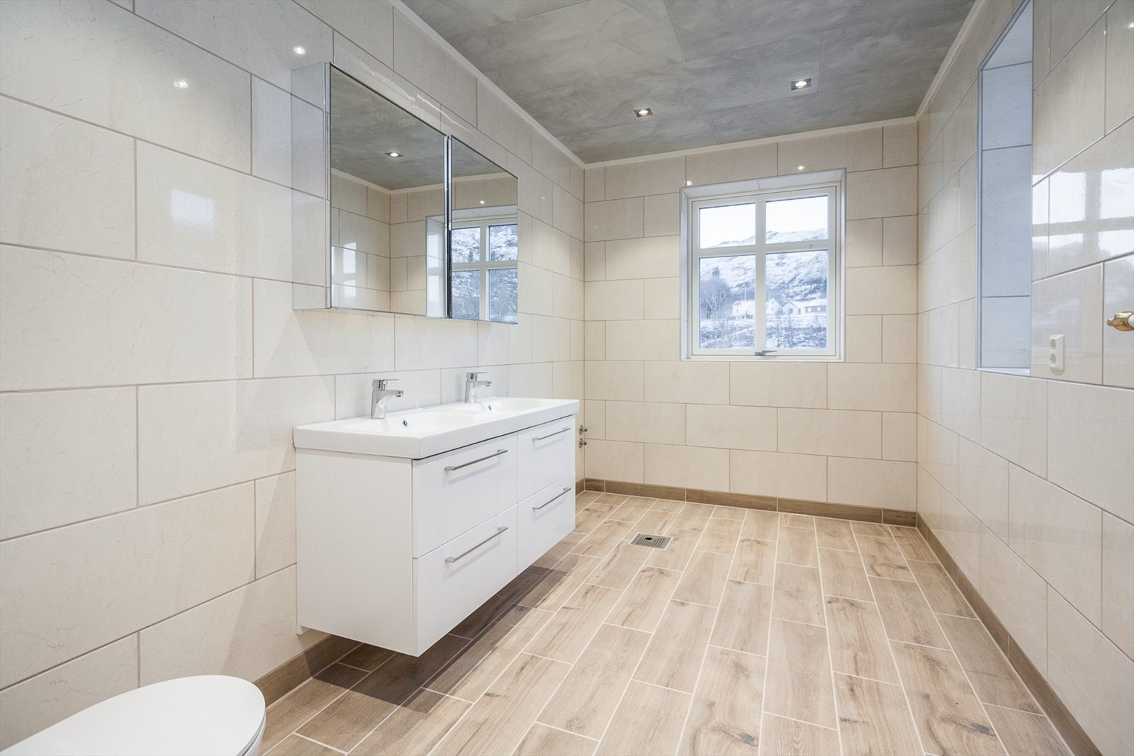 Badet er i lekker beige utførelse med fliser på gulv og vegger. Galleribilde