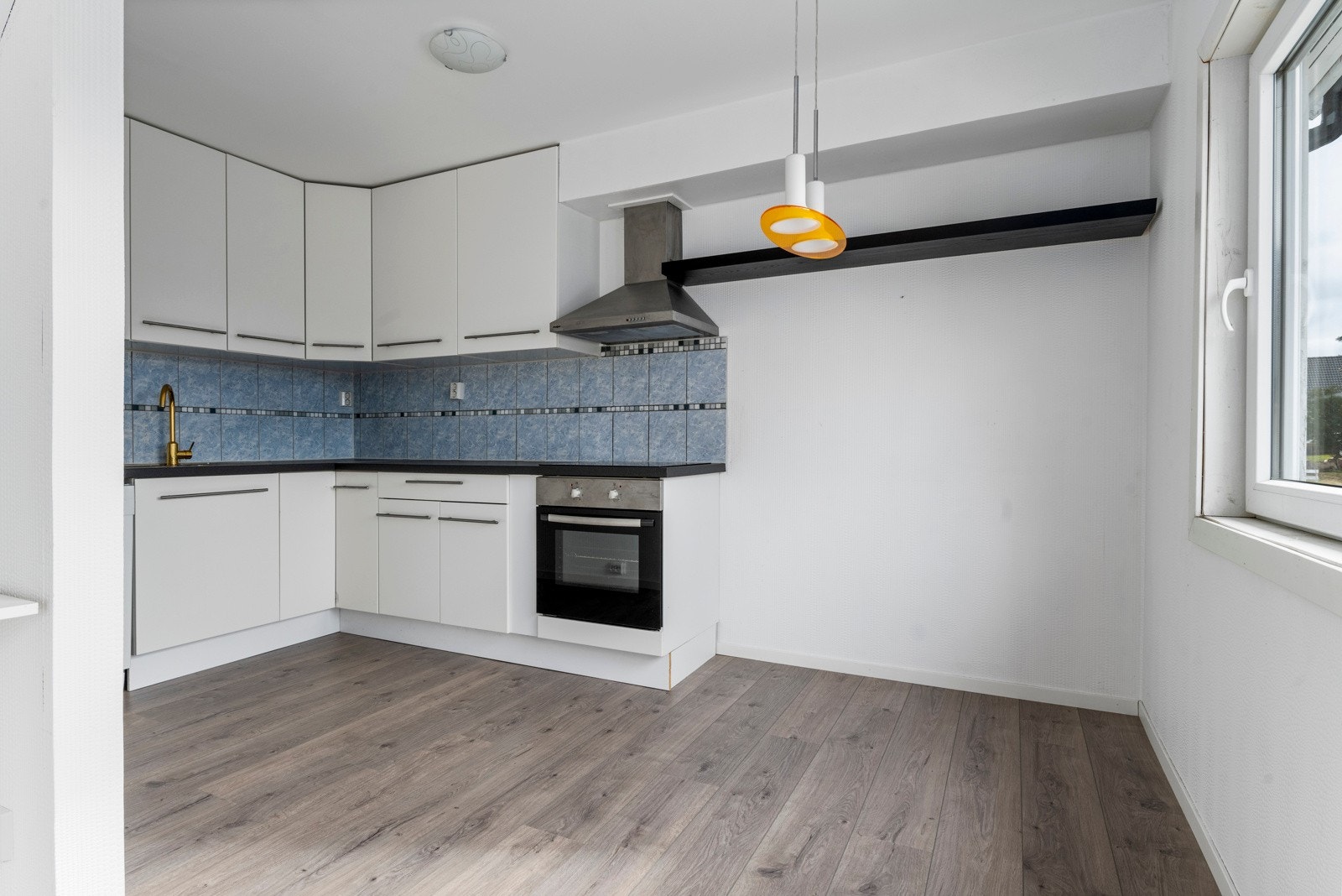 Lys kjøkkeninnredning og plass til spisebord. Galleribilde