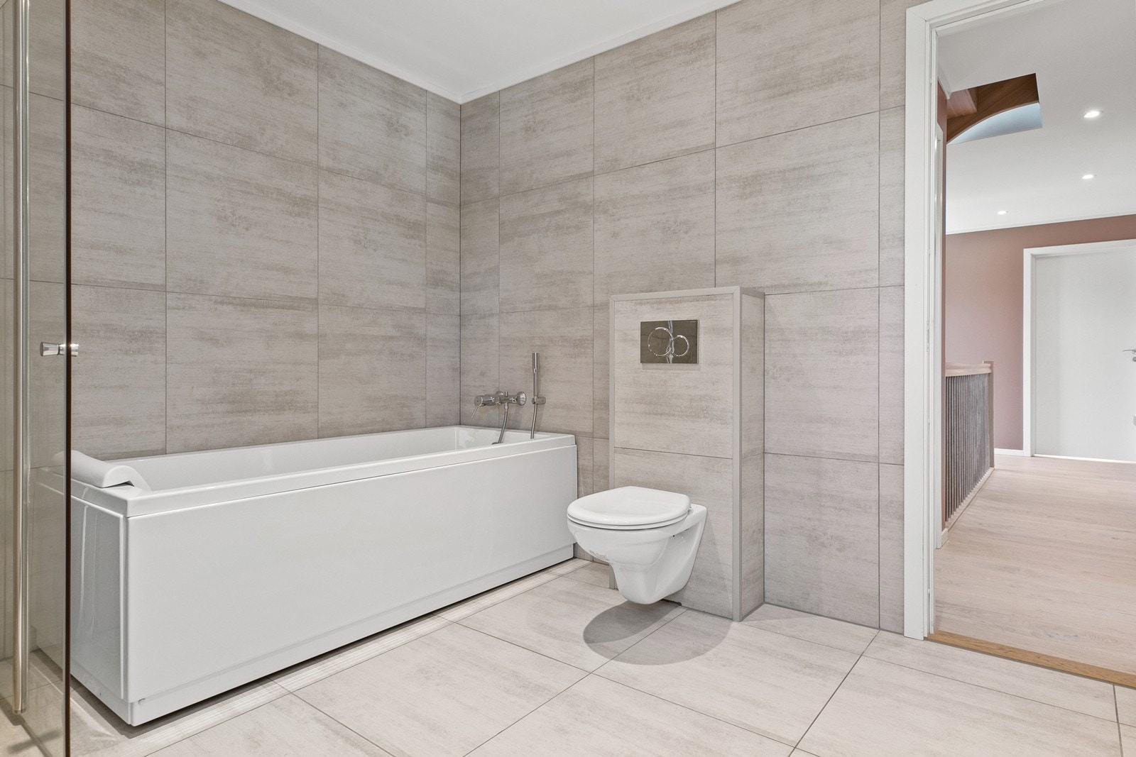 Badet består av servant på skap, dusjhjørne, badekar og vegghengt wc. Galleribilde