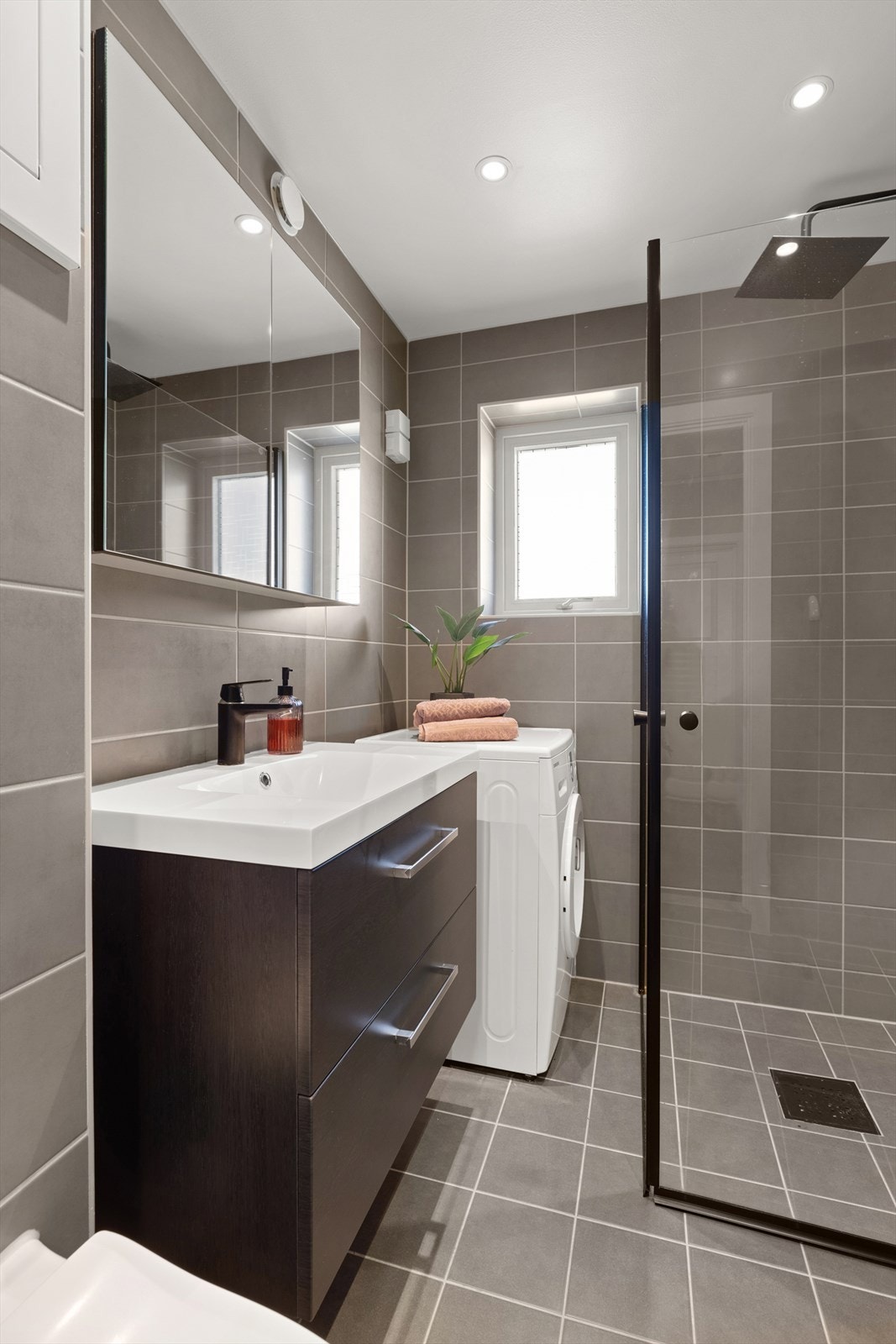 Badet har varme i gulvet og opplegg for vaskemaskin Galleribilde