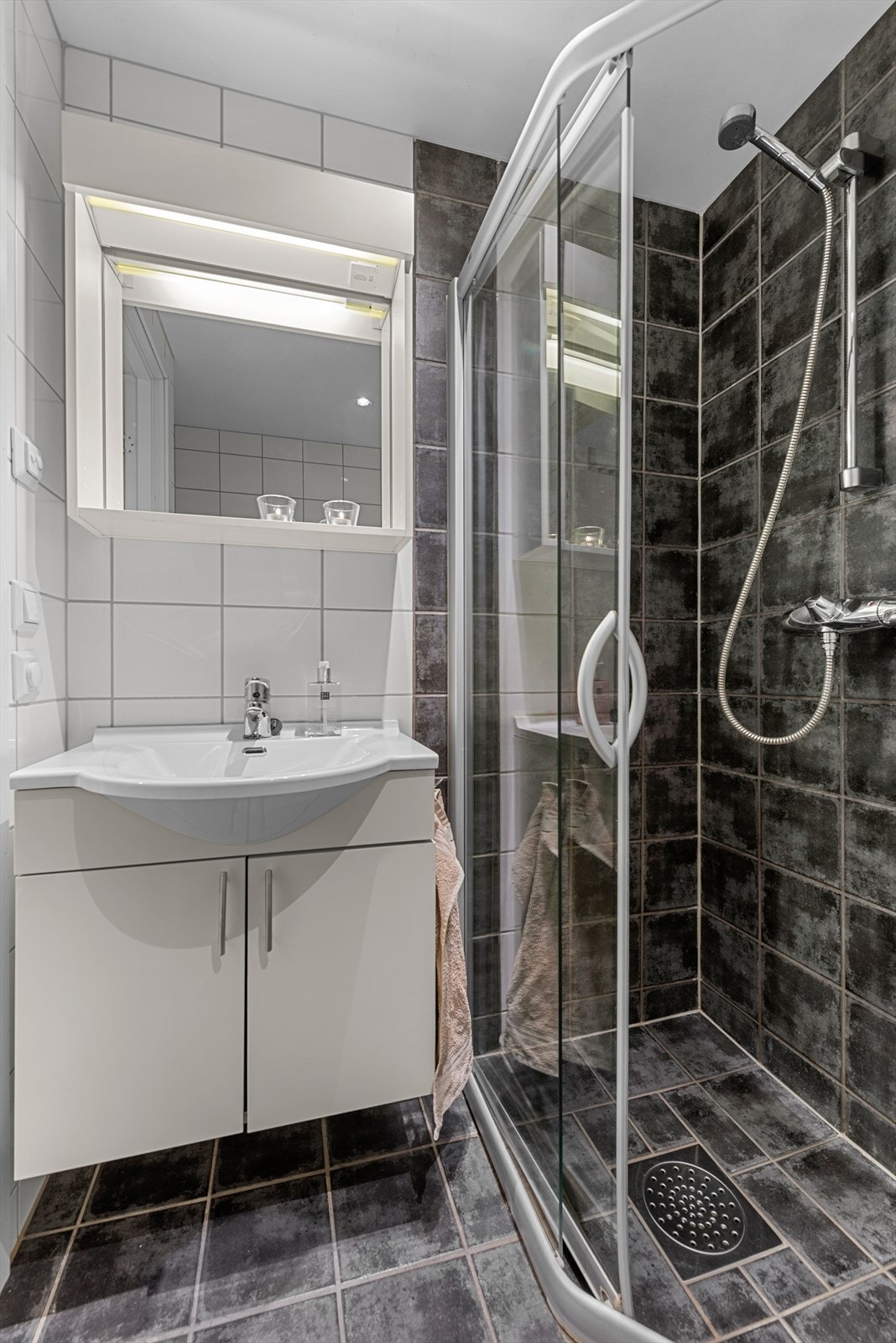 Flislagt bad på 3,2 m² innredet med toalett, dusjhjørne og baderomsinnredning. Galleribilde