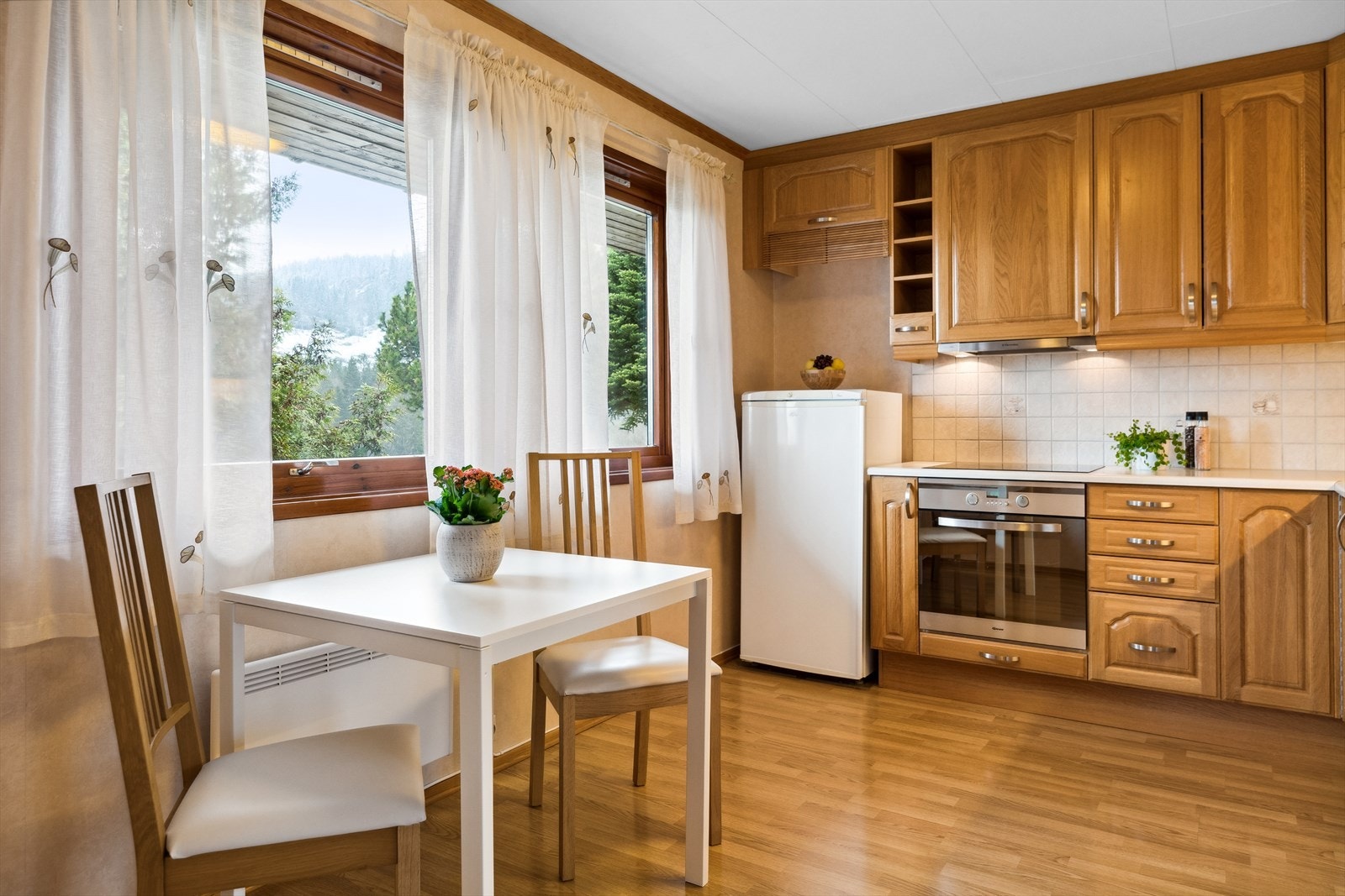 Kjøkkenet har egen spiseplass ved to vinduer. Galleribilde