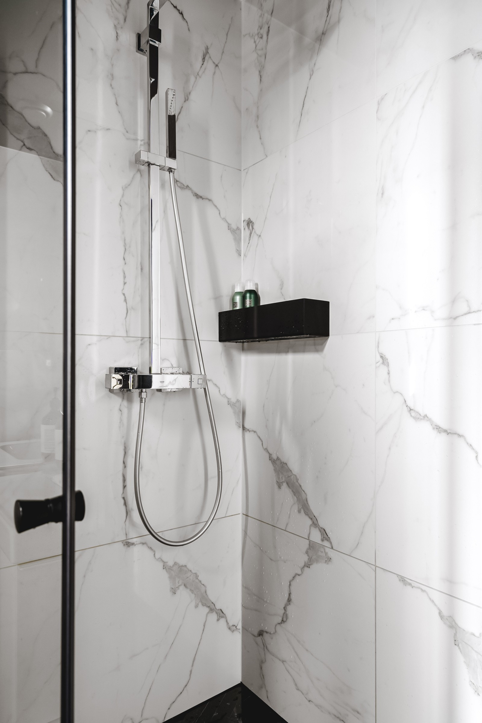 Badet er utstyrt med stort dusjhjørne, opplegg for vaskemaskin og vegghengt wc.