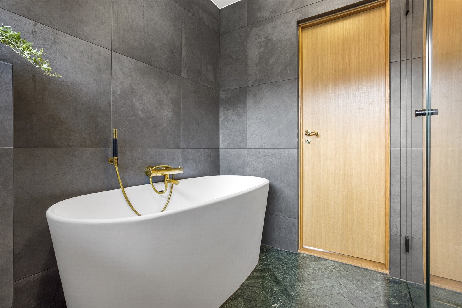 Badet har badekar og dusjhjørne med regnfallsdusj Galleribilde