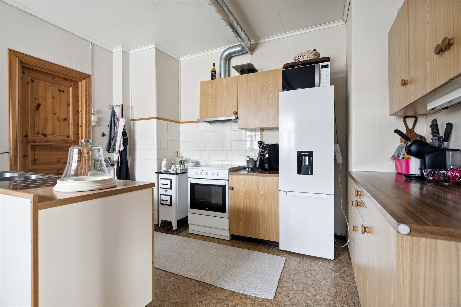 Kjøkkenet i andre etasje har eldre innredning med glatte fronter på over og underskap, benkeplate i laminat med doble oppvaskkummer i stål og utslagsvask i stål. Kjøkkenet har plass til kjøl/fryseskap, oppvaskmaskin og komfyr. Galleribilde