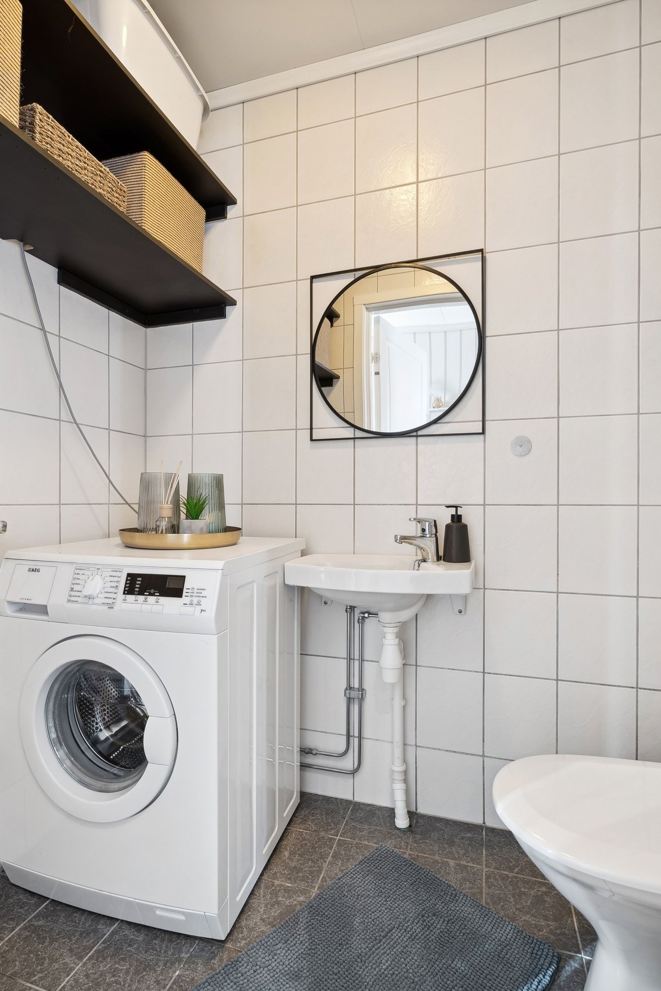 Gjestetoalett nede, med opplegg for vaskemaskin. Galleribilde