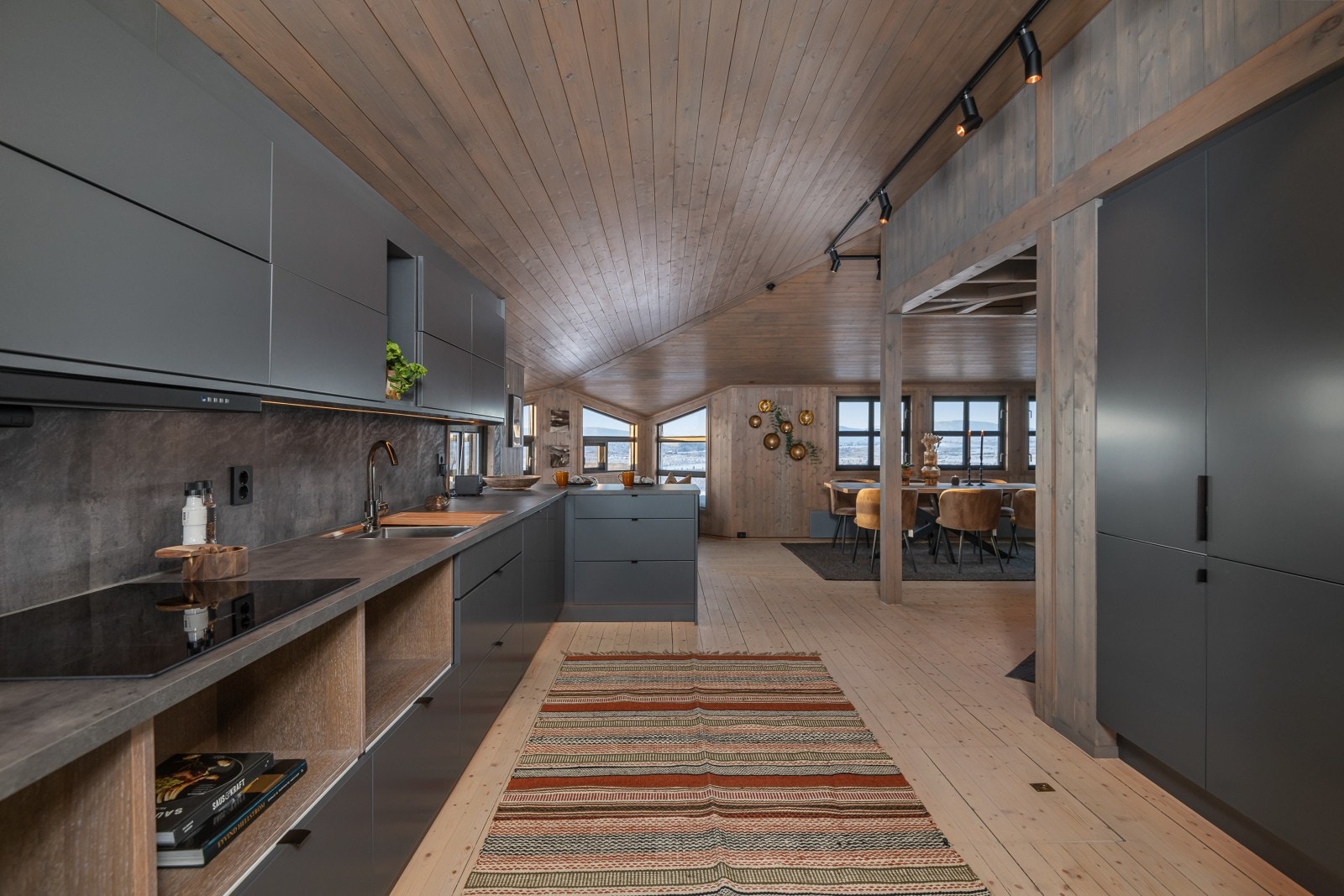 Her er det kjøkkeninnredning med laminerte skrog, glatte fronter, laminert benkeplate, belysning over benkeplate, plater over benkeplate, dobbel kjøkkenkum. Galleribilde